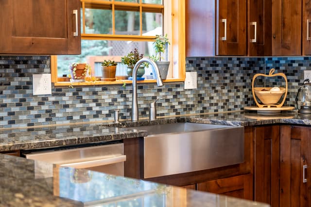a detail shot of a modern kitchen sink and backsplash
