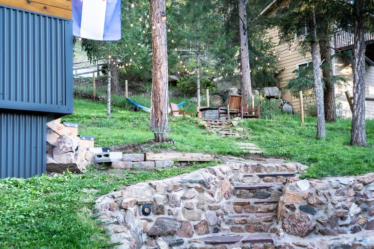a quaint, green back yard with flagstone and nice lighting